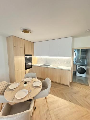 a dining room with a table and chairs and a kitchen at J&M apartman in Liptovská Teplá