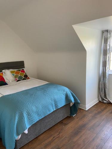a bedroom with a bed with a blue comforter at Daline House Clonakilty in Clonakilty