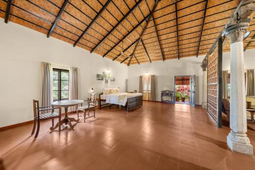 a bedroom with a bed and a table in a room at Magnolia Estates & Resorts in Virajpet