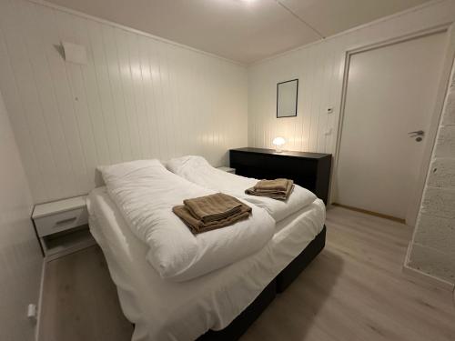 a bedroom with a large white bed with towels on it at Modern basement apartment, 65 square meters in Alta