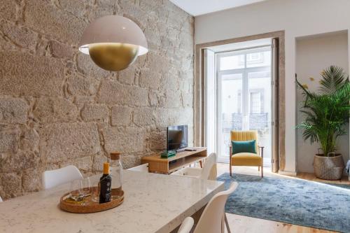 a living room with a table with a bottle of wine at Old Stone Flats by Host Wise in Porto