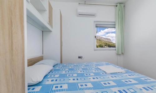 a bedroom with a bed and a window with a mountain at Miljak in Duće
