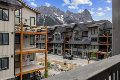 a group of apartment buildings in front of a mountain at Luxury Mountain Haven Views Hot Tub Central Bridgette Bar Main St in Canmore