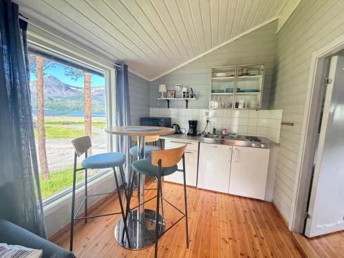 a kitchen with a table and stools in a room at Mørsvikbotn Camping AS in Mørsvik