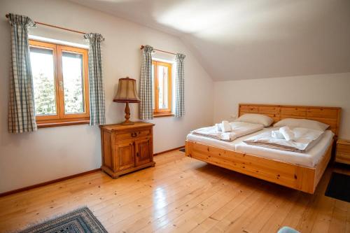 a bedroom with a bed and a lamp and windows at Haus Uschi in Klagenfurt