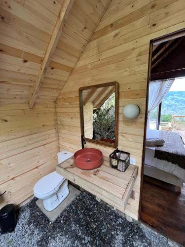 a wooden bathroom with a toilet and a mirror at Cúspide Lodge - Choachí in Choachí