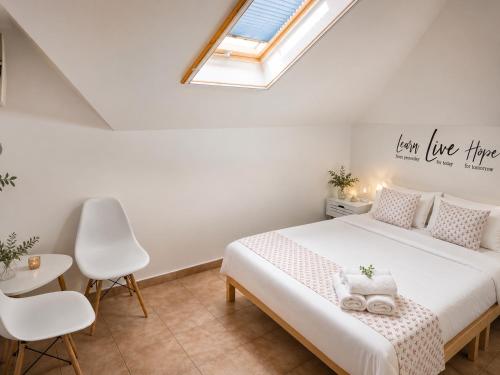 a bedroom with a white bed and a skylight at Vila Matt in Vama Veche