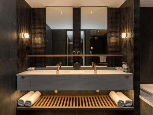 a bathroom with a large sink and a mirror at Novotel Sydney Cabramatta in Cabramatta