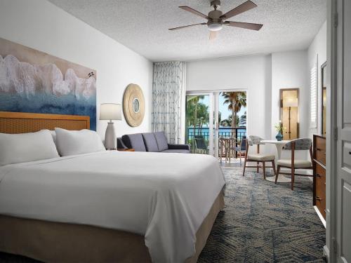 a bedroom with a large bed and a living room at Ocean Pointe Resort Two-Bedroom Villa in Palm Beach Shores