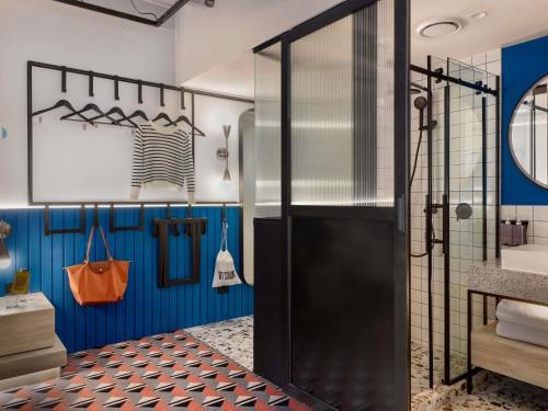 a bathroom with a shower with blue walls at TRIBE Auckland in Auckland