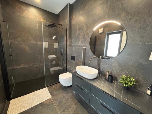 a bathroom with a sink and a toilet and a mirror at Brúarárbyggð A2 in Blaskogabyggo