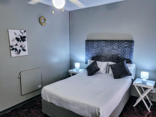 a bedroom with a large bed with two night stands at Golf Road Guesthouse in Pietermaritzburg