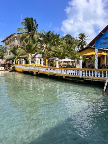 eine Brücke über einen Fluss mit Palmen und Gebäuden in der Unterkunft Hotel Cocotal in Isla Grande