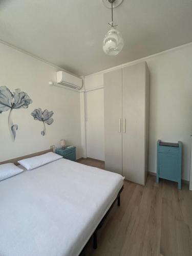 a bedroom with a white bed and a blue cabinet at MareMare Follonica in Follonica