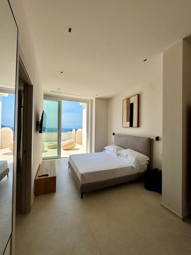 a bedroom with a bed and a view of the ocean at Fenici Levanzo Hotel - Adults Only in Levanzo