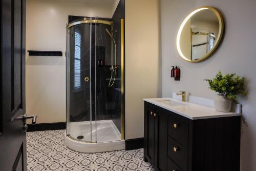 a bathroom with a shower with a sink and a mirror at The Clyffe Hotel in Lowestoft