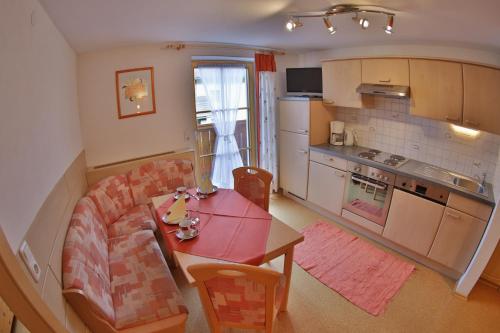 a living room with a table and a kitchen at Haus Regina in Strobl