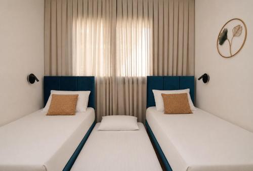 two beds sitting next to each other in a room at GABRIEL APARTMENTS - Jacuzzi & Panoramic JLM View Steps to Shaare Zedek Hospital in Bayit Wegan