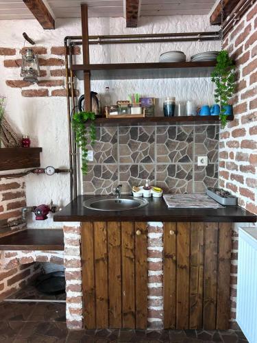 a kitchen with a sink and a brick wall at Kompleks MINAMI in Ohrid