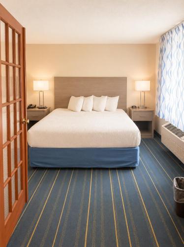 a hotel room with a large bed and two lamps at Days Inn by Wyndham Hinckley in Hinckley