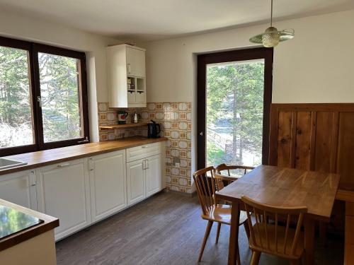 a kitchen with white cabinets and a wooden table at Mountainview Flattnitz in Flattnitz