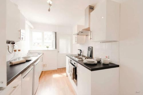 a kitchen with white cabinets and a black counter top at Doncaster Budget Room in Shared House w Kitchen in Doncaster