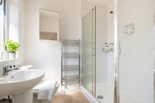 a white bathroom with a sink and a shower at Doncaster Budget Room in Shared House w Kitchen in Doncaster