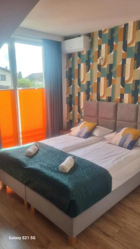 a large bed in a room with a large window at Wrzosowa 34 in Augustów