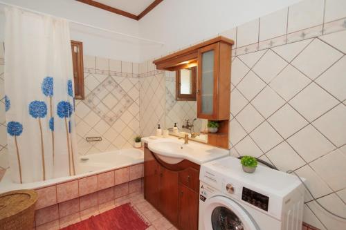 a bathroom with a sink and a washing machine at Mystras Balcony View in Mystras