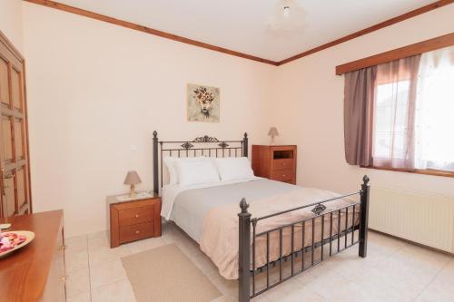 a bedroom with a bed and a table and a window at Mystras Balcony View in Mystras