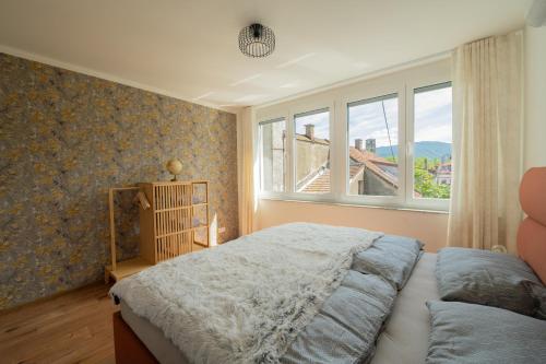 a bedroom with a large bed and a window at Apartment Center Korzo 2 in Bihać