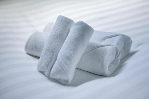 a pile of white towels on a bed at T-home彩 in Tokyo