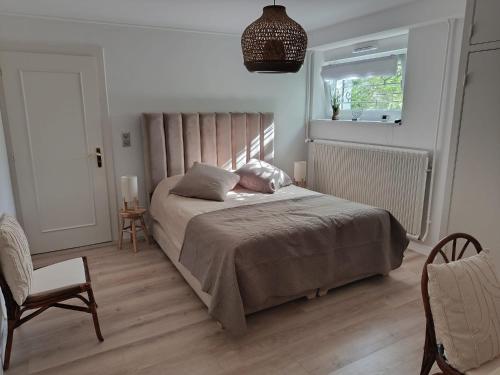 a bedroom with a bed and a chair and a window at Très belle chambre à Metz in Metz