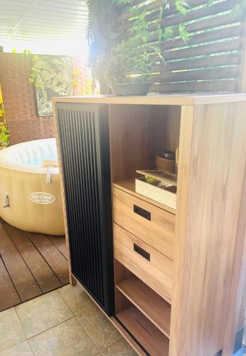 a wooden cabinet with drawers and a bath tub at Escale verdoyante in Petit-Bourg