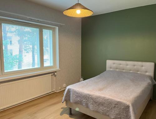 a bedroom with a bed and a large window at Spacious one room apartment in Vaasa