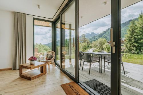 a room with glass doors and a table with a view at Domki Tymianek & Melisa in Kościelisko