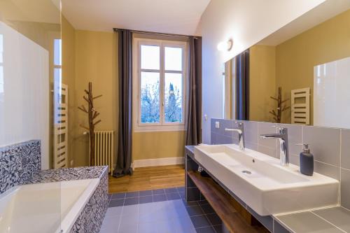 a bathroom with two sinks and a large mirror at L'Autre Rives in Albi