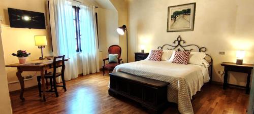 a bedroom with a bed and a table and a desk at Casa Becci Central Bright & Cozy Flat in San Gimignano
