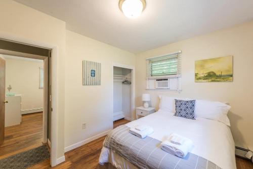 a bedroom with a white bed and a window at Beach House with Spacious Deck for Entertaining in Narragansett