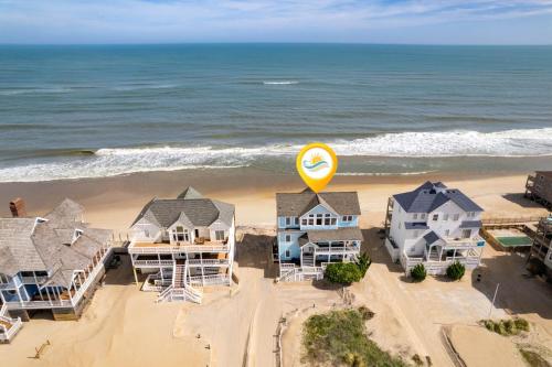 an aerial view of a beach with houses and a yellow sign at 8046 - Sun Runner in Rodanthe