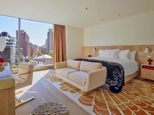 a hotel room with a large bed and a couch at Faena New York in New York