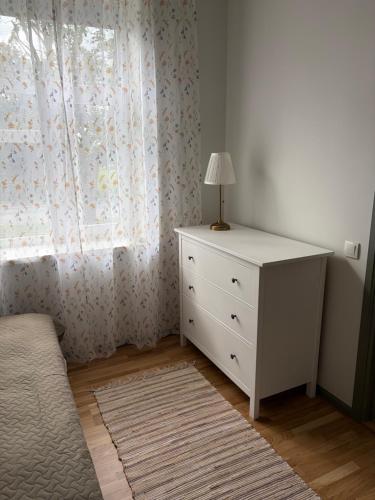 a bedroom with a white dresser and a window at Aia Home in Kuressaare