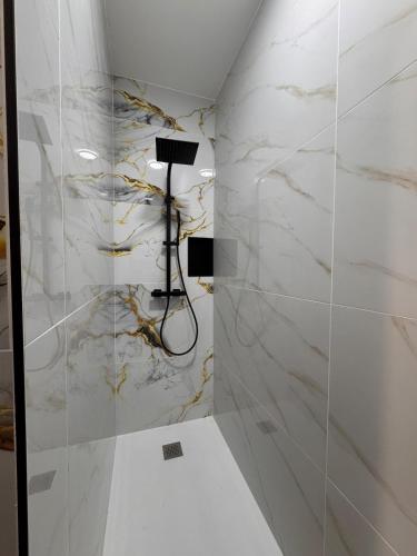 a bathroom with white marble walls and a lamp at 101 - Centre de voiron in Voiron