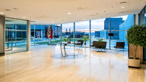 a lobby with a table and chairs and windows at ARVA Abad San Antonio in León