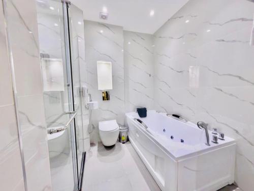 a white bathroom with a shower and a sink and a toilet at Petra Legacy Luxury in Petra