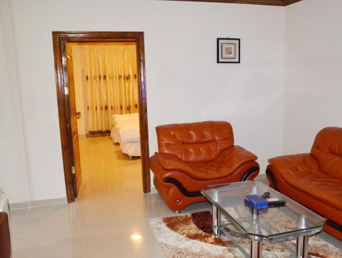 a living room with two chairs and a table at The Apartments By Sedrah in Irbid