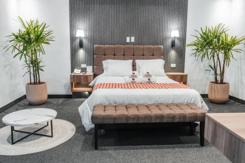 a bedroom with a large bed and two potted plants at El Portal Del Marques in Cajamarca