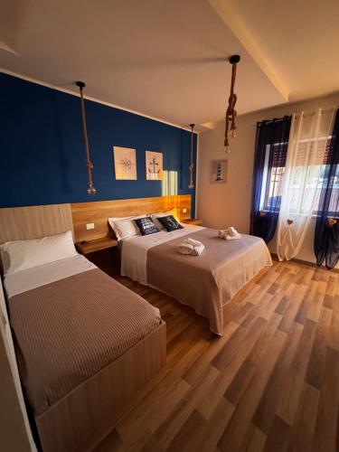 a bedroom with two beds and a blue wall at Tramonto di Calabria in Pizzo