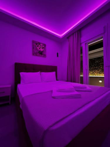 a purple bedroom with a large bed with purple lighting at Thomas Luxury home in Plisioí