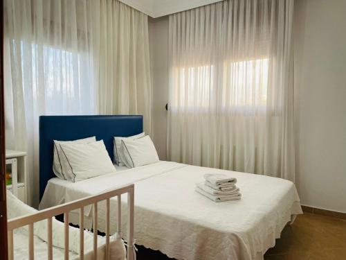 a bedroom with a bed with white sheets and a window at The Greek Mama's Cottage in Epanomi